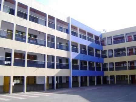 Les bâtiments de classes et leurs coursives bleues et blanches.