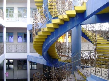 L'escalier hélicoïdal bleu et jaune qui relie les étages autour du patio.